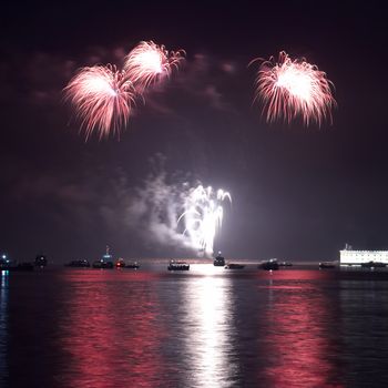 Red colorful holiday fireworks on the black sky background.