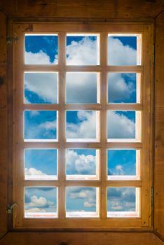 Wooden window with beautiful view to blue sky and clouds