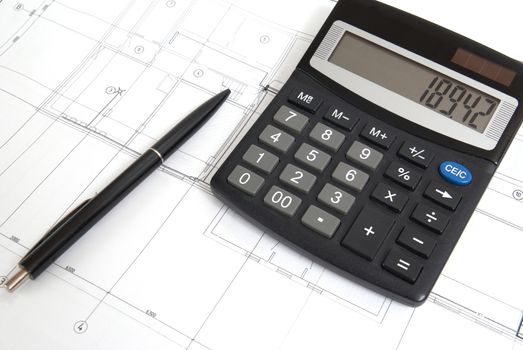 Calculator and pen on a blueprint. Engineering equipment.