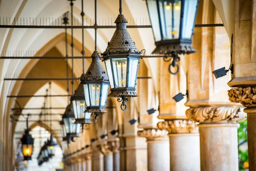 Row of lamps. Passage in gothic hall with columns