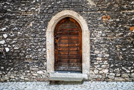 Old wooden door with stone wall on the ancient street