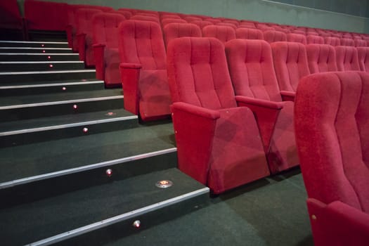 Aisle with rows of red seats in the modern theater