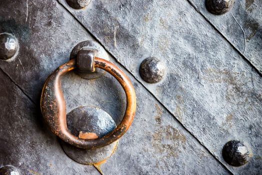 Old black metal door in temple gate with ring knocker