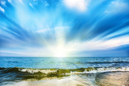 Sunset on tropical beach and blue sea, white clouds on background