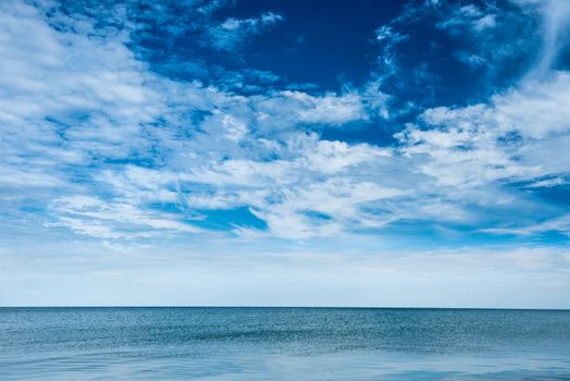 Blue clear sea and sky with white clouds