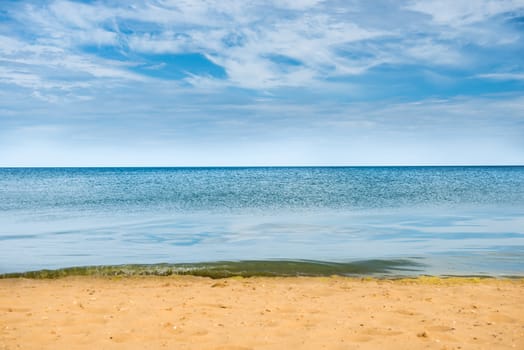 Beautiful summer sea abstract background. Golden sand beach with blue ocean and cloudscape and sunset