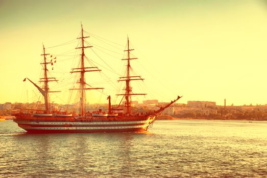 Beautiful ship sailboat in the blue sea comes into bay. Colorized with instagram filter like old image