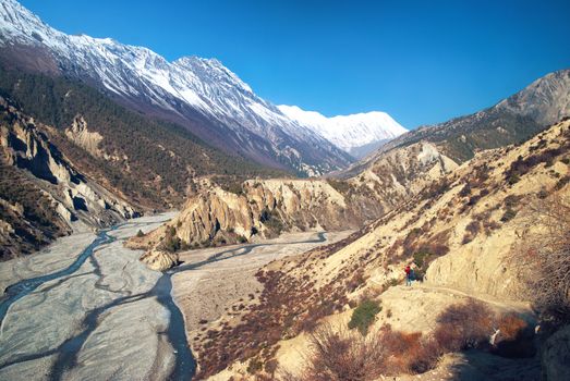 View of Himalayas mountains from Annapurna trek. Man standing on the path above Marsyangdi river