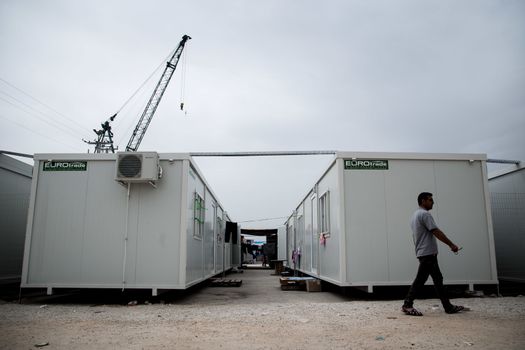 GREECE, Skaramagas: As thousands of refugees remain stranded in Greece, a man walks past several storage containers serving as homes for 1,000 people at a new camp in Skaramagas, near Athens on April 14, 2016. They have just been relocated here after being stranded at the port of Piraeus, where they originally landed.