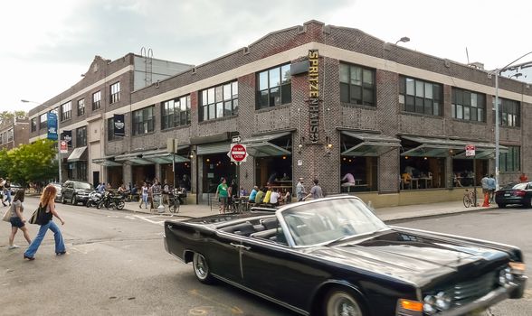 Brooklyn, New York - August 17, 2014: Vintage car and pedestrians before drink bar at Greenpoint