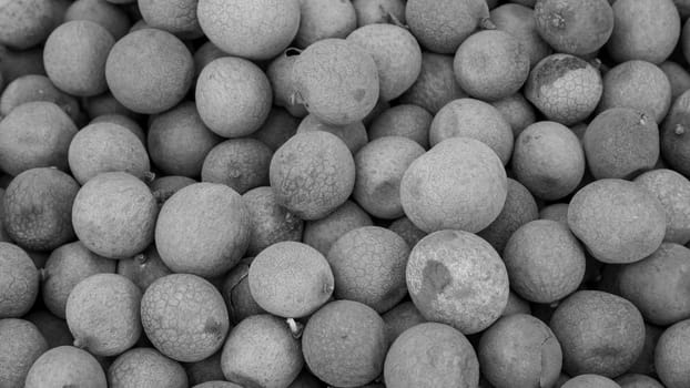 The close up of group of fresh longan at fruit market. (black and white tone)