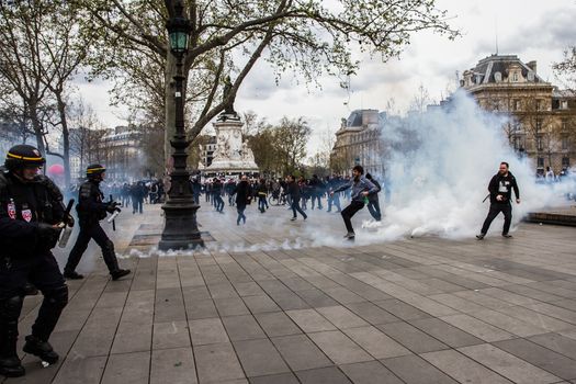 FRANCE, Paris: Protesters run away from tear gas thrown by riot policemen as hundreds demonstrate against the French government's proposed labour law reforms on April 14, 2016 in Paris. Fresh strikes by unions and students are being held across France against proposed reforms to France's labour laws, heaping pressure on President Francois Hollande who suffered a major defeat over constitutional reforms on March 30.