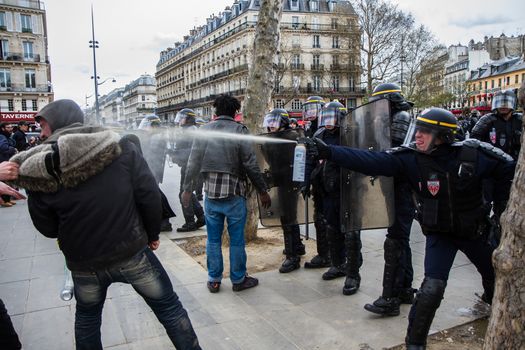 FRANCE, Paris: A riot policeman throws tear gas at a protester as hundreds demonstrate against the French government's proposed labour law reforms on April 14, 2016 in Paris. Fresh strikes by unions and students are being held across France against proposed reforms to France's labour laws, heaping pressure on President Francois Hollande who suffered a major defeat over constitutional reforms on March 30.
