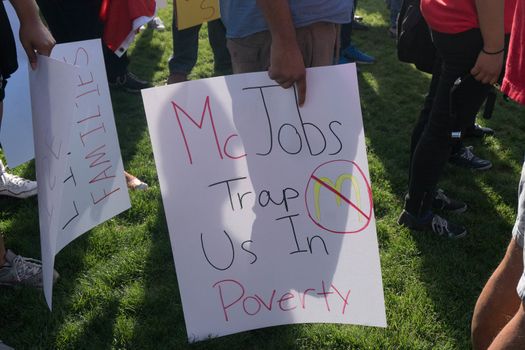 UNITED STATES, Phoenix: A protester holds a sign reading 'McJobs trap us in poverty' as hundreds of workers and supports took to the streets in Phoenix, Arizona on April 14, 2016 to call for a national minimum wage increase to  an hour. 