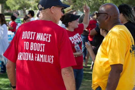 UNITED STATES, Phoenix: A protester wears a tshirt reading 'boost wages to boost Arizona families' as hundreds of workers and supports took to the streets in Phoenix, Arizona on April 14, 2016 to call for a national minimum wage increase to  an hour. 