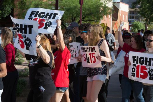 UNITED STATES, Phoenix: Protester hold signs reading 'Fight for 15' as hundreds of workers and supports took to the streets in Phoenix, Arizona on April 14, 2016 to call for a national minimum wage increase to  an hour. 