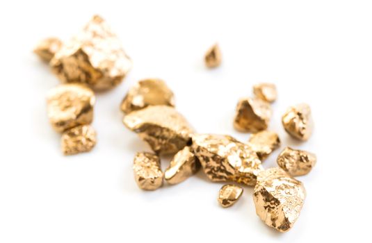 handful of gold nuggets close-up on a white background