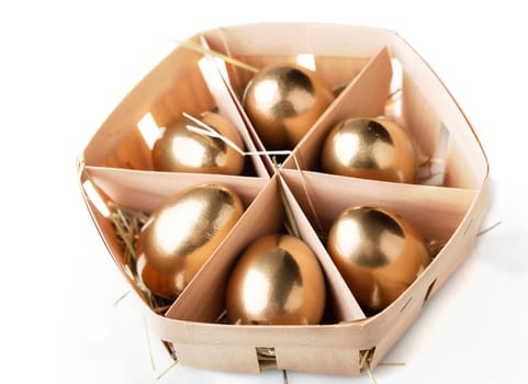 golden eggs in a basket on white background