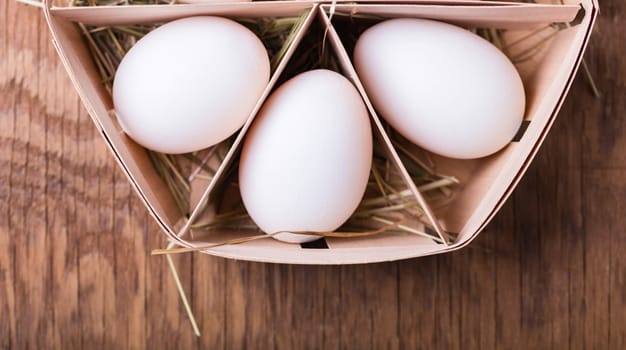chicken eggs in basket on wooden background