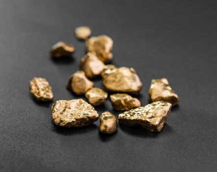 handful of gold nuggets close-up on a black background