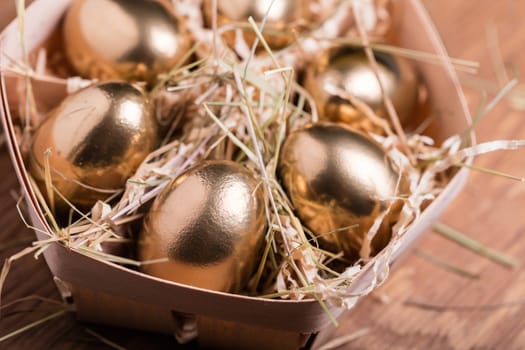 golden chicken eggs closeup on wooden background
