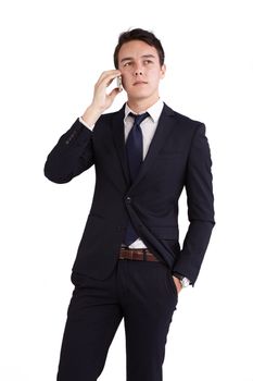 A young caucasian male businessman looking unhappy holding a mobile phone looking away from camera.