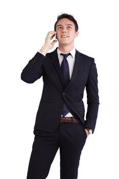 A young caucasian male businessman looking happy holding a mobile phone looking away from camera.