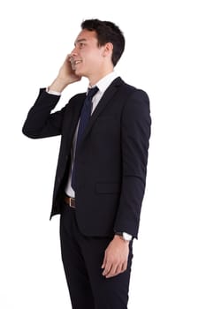 A young caucasian male businessman looking happy holding a mobile phone looking away from camera.