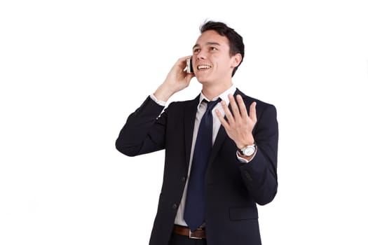 A young caucasian male businessman smiling holding a mobile phone while raising his hand looking away from camera.