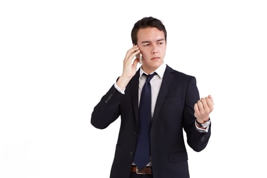 A young caucasian male businessman frowns with raised hand while holding a mobile phone looking away from camera.