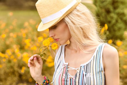 Beauty playful woman relax in summer garden dreaming, people, outdoors, bokeh. Attractive happy blonde girl in hat with flower enjoying nature, harmony on meadow, lifestyle.Sunny day, forest,copyspace