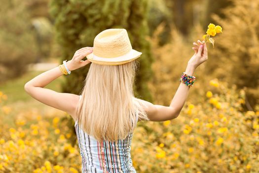 Beauty playful woman relax in summer garden dreaming, people, outdoors, bokeh. Attractive happy blonde girl in hat with flower enjoying nature, harmony on meadow, lifestyle.Sunny day, forest,copyspace