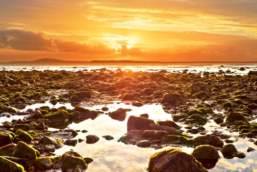 reflections at rocky beal beach near ballybunion on the wild atlantic way ireland with a beautiful yellow sunset