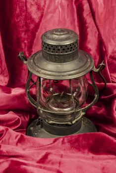 Old oil lantern isolated on red background