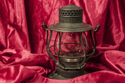 Old oil lantern isolated on red background