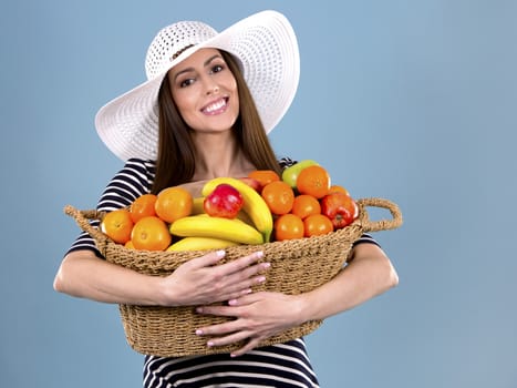 young caucasian woman holding fruit basket on white background