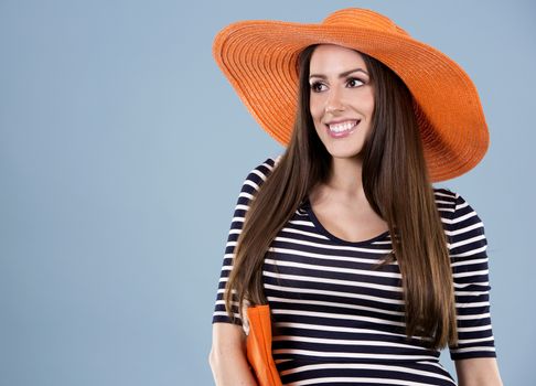 young woman wearing dress and orange hat on blue background