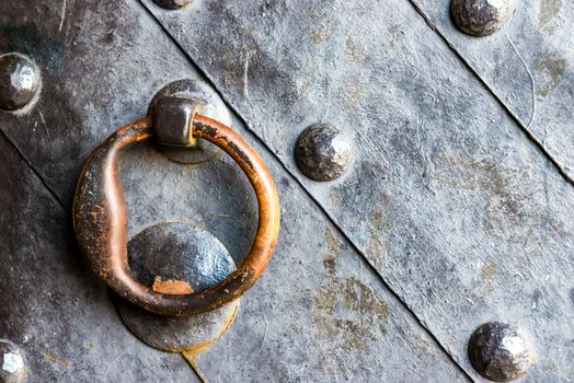 Old black metal door in temple gate with ring knocker