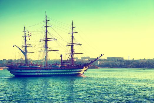 Beautiful ship sailboat in the blue sea comes into bay. Colorized with instagram filter