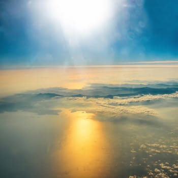 Aerial view of sunset on the sky with sunrays. Fluffy clouds background