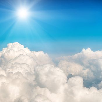 Blue clouds and sky. Shining sun on natural background