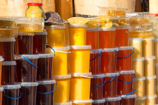 Many jars with honey on farm market