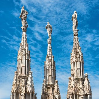 White marble statues on the roof of famous Cathedral Duomo di Milano on piazza in Milan, Italy