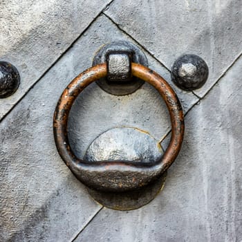 Old black metal door in temple gate with ring knocker