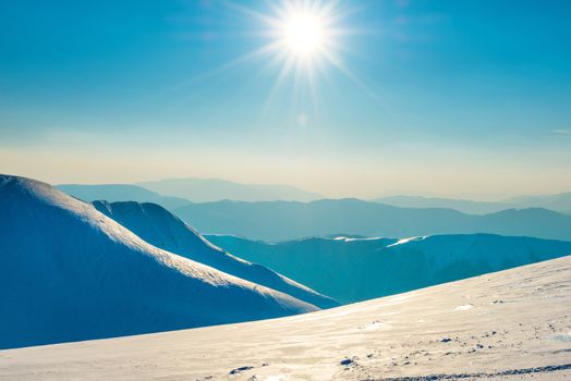 Bright sun in winter mountains covered with snow