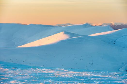 Sunset in winter mountains covered with snow.