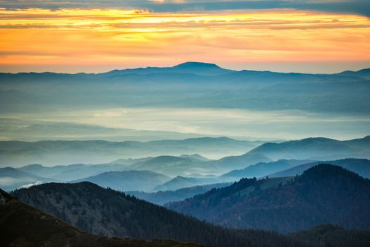 Blue mountains and hills under beautiful orange sunset