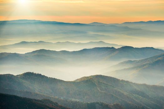 Blue mountains and hills under beautiful orange sunset