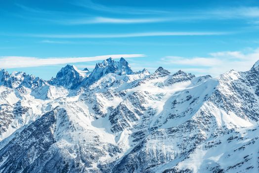 Landscape with snow in blue mountains over sky and clouds