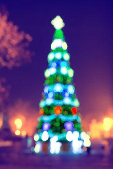 Blured blue christmas tree with colorful magic lights